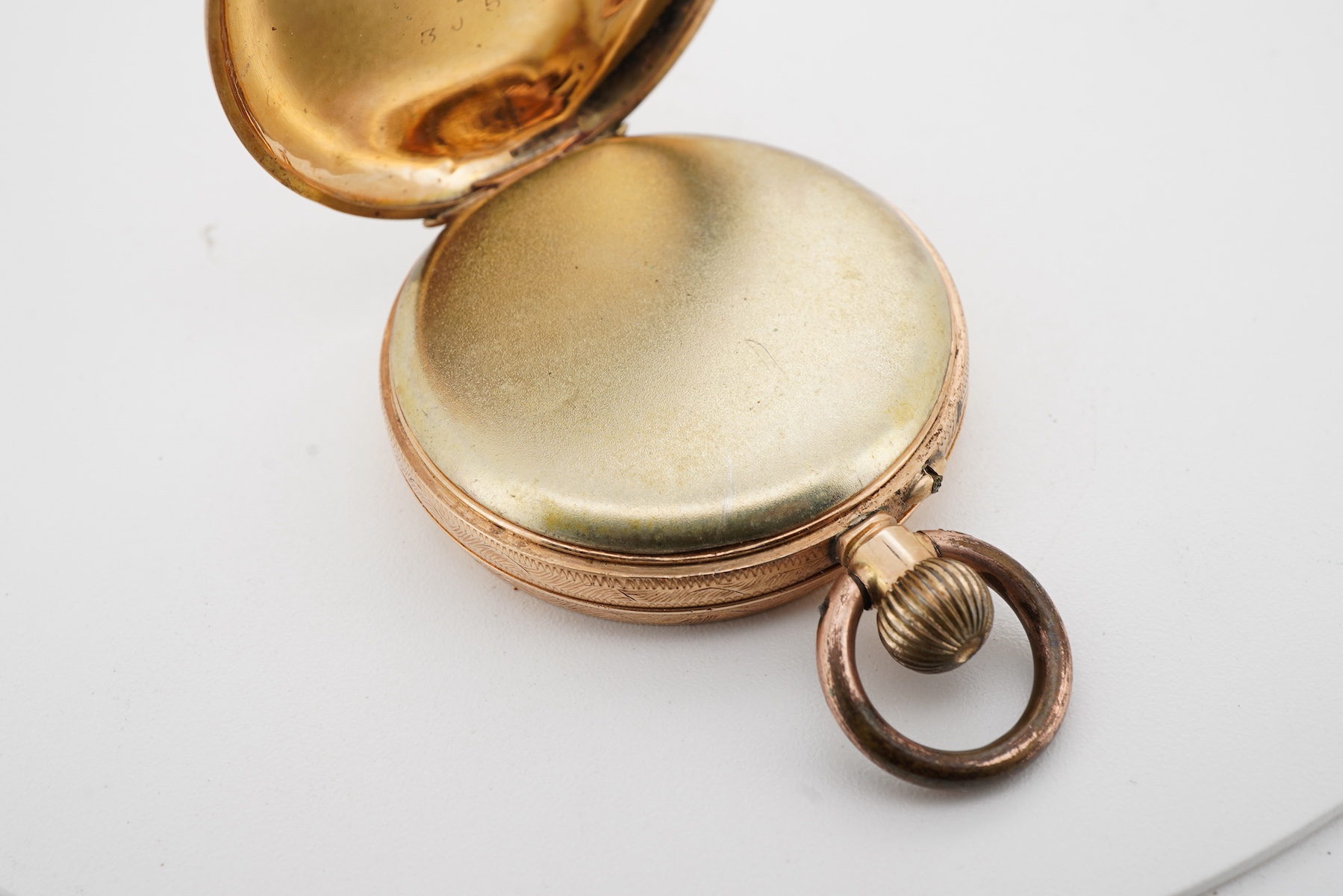 A lady's late 19th century Swiss engraved 14k keyless open faced fob watch, lacking glass, case diameter 32mm, with gilt metal inner cuvette, gross weight 27.6 grams.